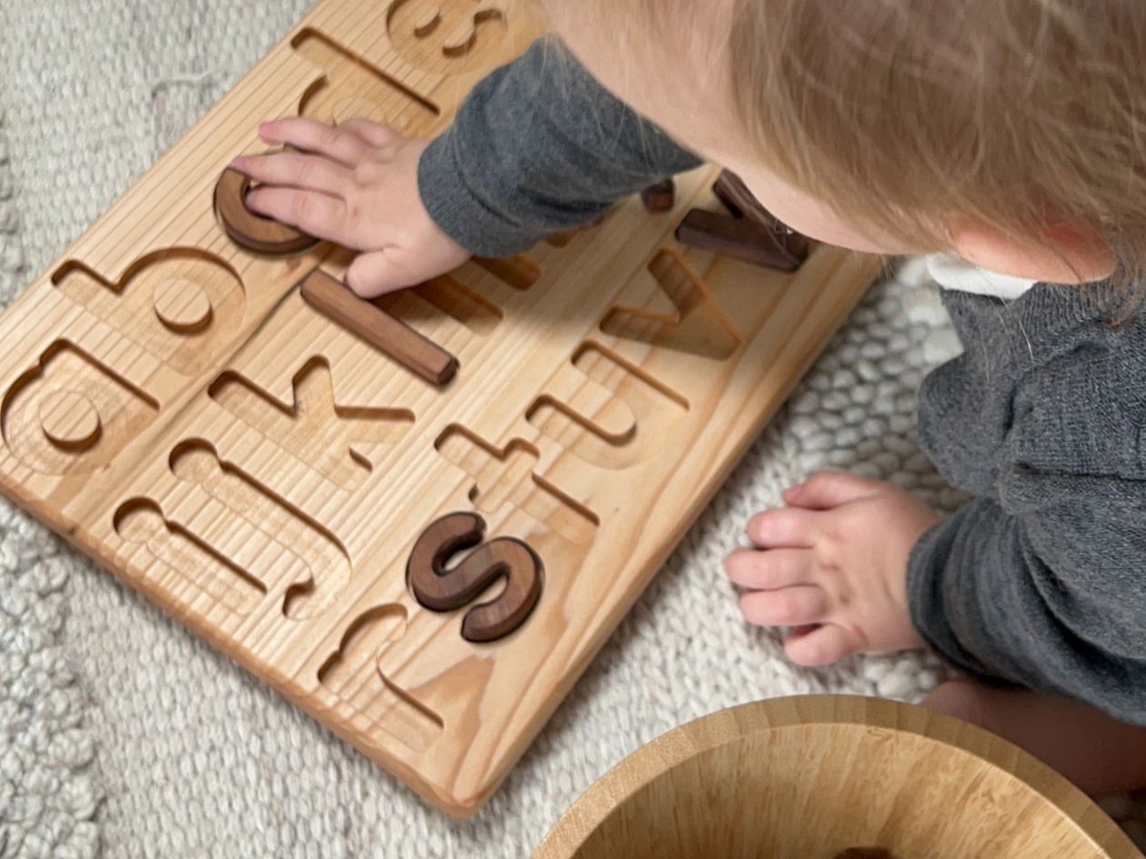 Kind spielt mit Holzpuzzle / Lernspielzeug - GREEN & GROW Onlineshop