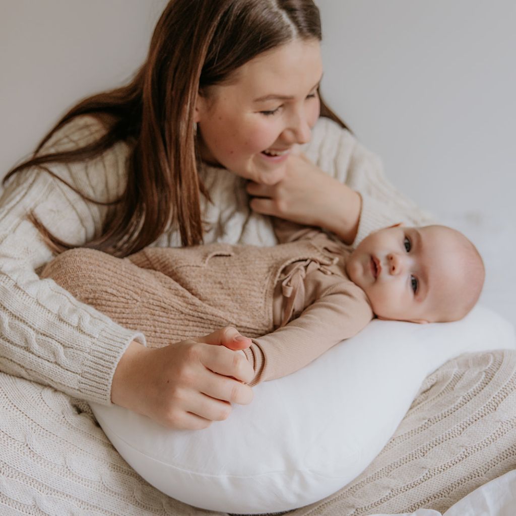 mama mit baby in stillkissen, ökologisches stillkissen aus biobaumwolle und kapok von cocoon company