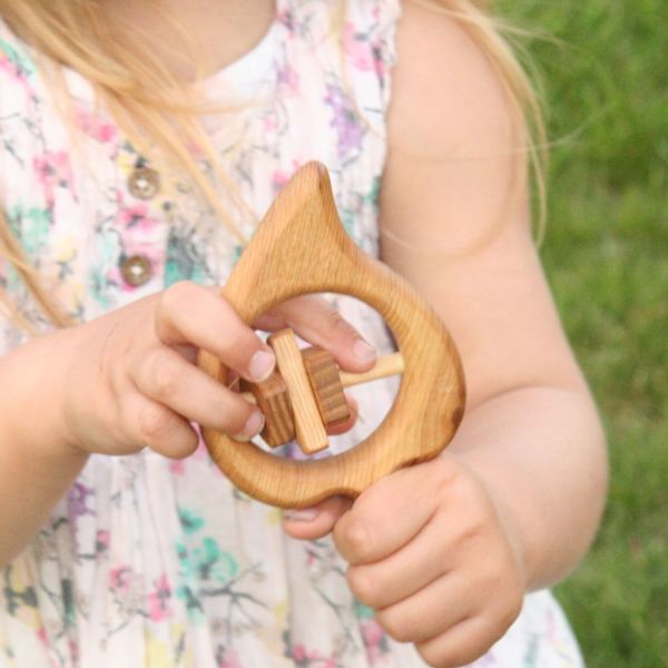 Kind spielt mit Rassel aus Holz, Klassisches Holzspielzeug bei green and grow