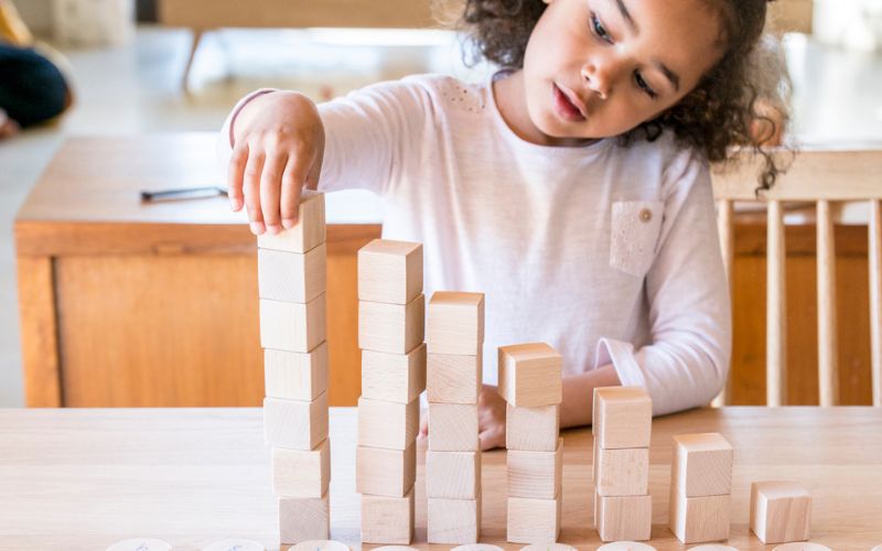 Kind spielt mit montessori holzspielzeug von grapat