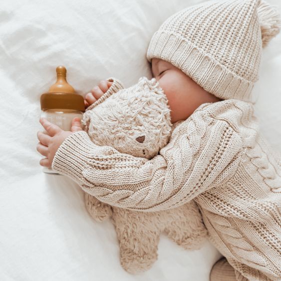 Baby schläft mit Glasfläschchen von Hevea Planet in der Hand; Baby-Glasfläschchen mit Latexsauger
