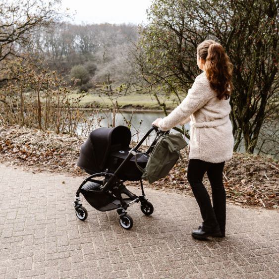 Elternteil schiebt Baby im Kinderwagen, Entdecke die praktische und ökologische Ausstattung für Unterwegs