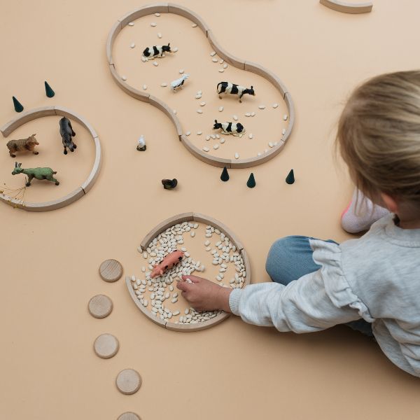 Kind spielt mit freiem Spielmaterial von Grapat und Abel, small world play